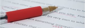 Close-up of typed manuscript page with corrections and red pen