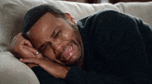 Gif of young man lying on couch crying