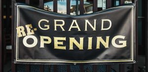 Black banner with yellow lettering: Grand Reopening, in front of store.