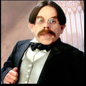 Middle-aged man with short dark hair and moustache and pale skin and glasses.