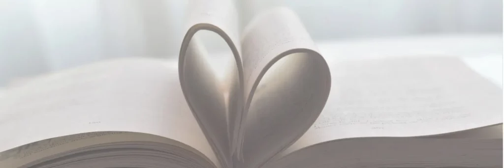 Open book with two pages curled up into a heart shape