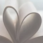 Open book with two pages curled up into a heart shape